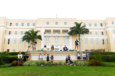 front exterior of a school with students in front